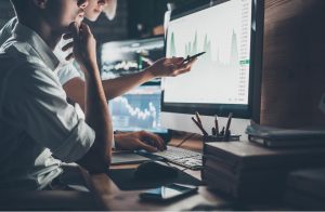 Two people looking at graph from Victorian property data report on computer screen